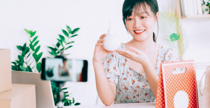 Woman taking a vlog style photo with a product