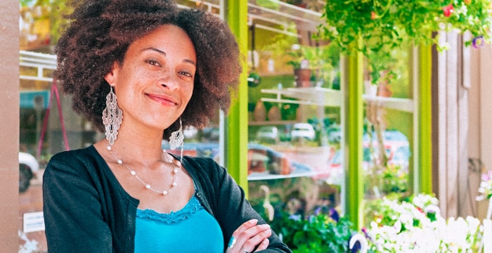 A woman smiles in front of a store